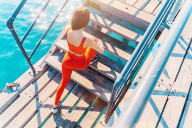 Kadın güneşli bir günde dışarıda egzersiz yapıyor.