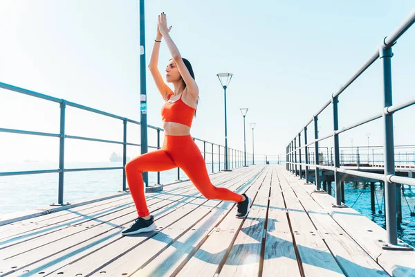 Mujer hace ejercicios de estiramiento de gimnasio al aire libre en un día soleado — Foto de Stock