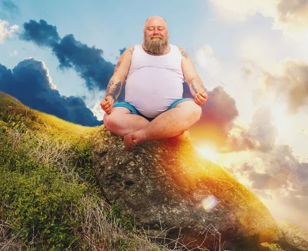 Hombre divertido con barba en posición de yoga al aire libre en una montaña — Foto de Stock