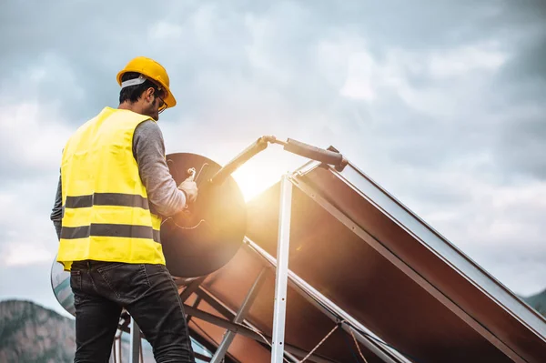 Människan monterar solpanel för varmt vatten i ett tak — Stockfoto