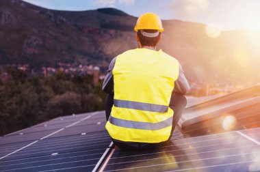 İşçiler elektrik için güneş panelinin üzerinde mola verdiler