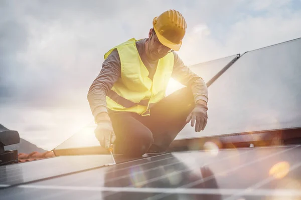 Der Mensch arbeitet an einem System erneuerbarer Energien mit Solarzellen für Strom und Warmwasser — Stockfoto