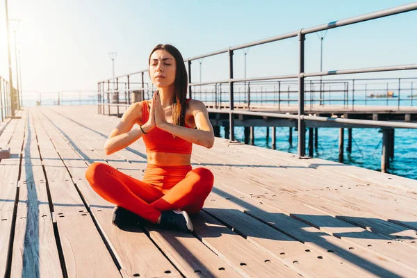 Mujer relajándose en posición de yoga en el verano frente al mar —  Fotos de Stock