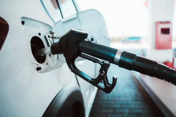 La pompa di carburante riempie un serbatoio di un'auto in una stazione — Foto Stock