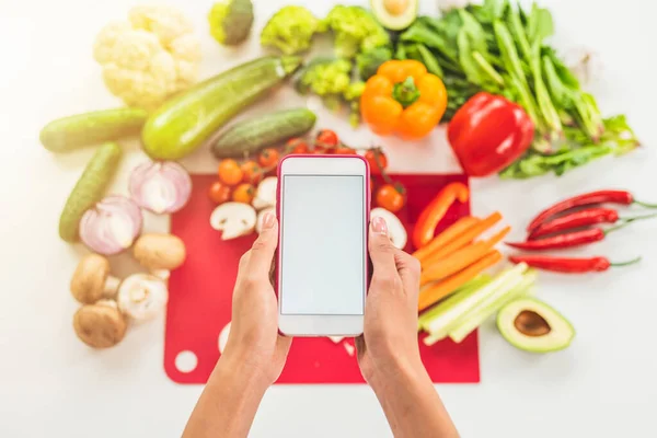 Шукайте рецепт в Інтернеті з мобільним телефоном на основі овочевих інгредієнтів — стокове фото