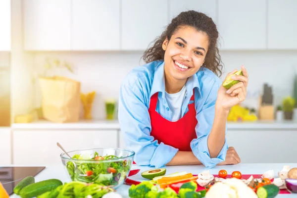 Νεαρή γυναίκα στην κουζίνα του σπιτιού ετοιμάζει μια αυθεντική σαλάτα με φρέσκα λαχανικά — Φωτογραφία Αρχείου