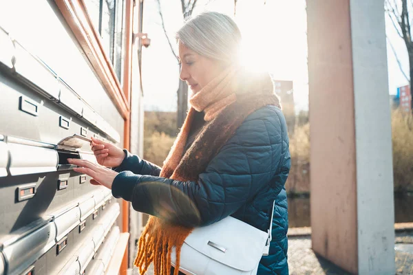 Senior woman opens the mailbox to check for new mails — стоковое фото