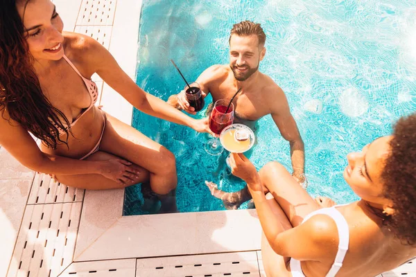 Mayolu bir grup arkadaş sahilde kokteyl içerler.