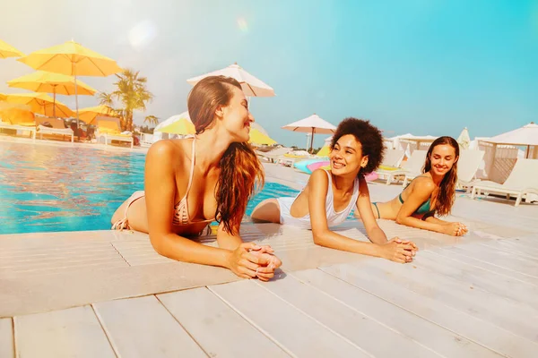Grupo de amigos em maiô desfrutar em uma piscina — Fotografia de Stock