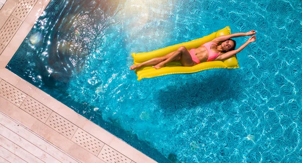 Fille en maillot de bain qui bronzent dans une piscine — Photo