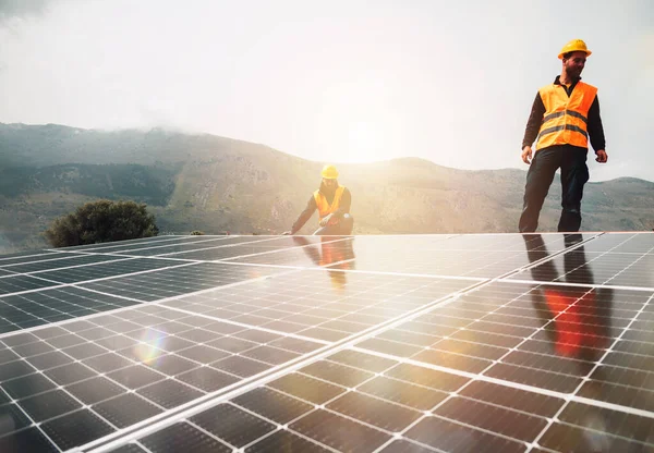 Οι εργαζόμενοι συγκεντρώνουν το ενεργειακό σύστημα με ηλιακό πάνελ για την ηλεκτρική ενέργεια — Φωτογραφία Αρχείου