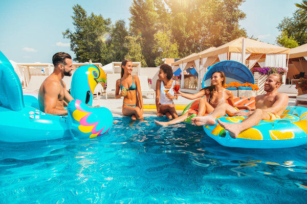 Group of friends in swimsuit enjoy in a swimming pool Stock Image