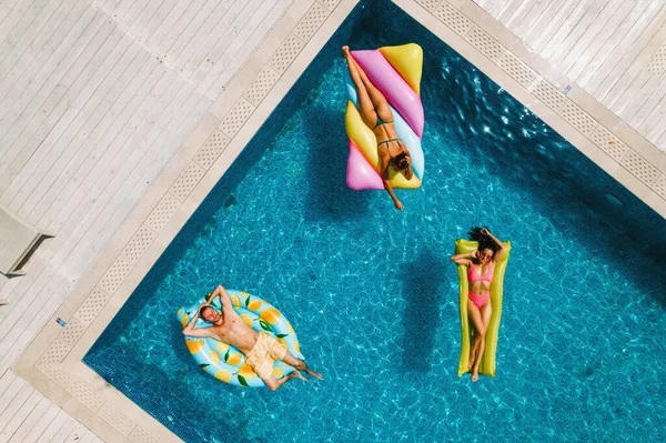 Des amis en maillot de bain dans la piscine bronzant — Photo