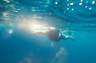 Gözlüklü sportif adam denizde hızlı yüzer.