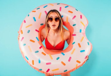 Elinde şişme donutla hayret verici bir kadın.
