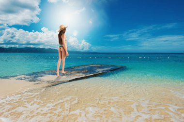 Woman relaxing under the hot sun at the crystalline sea
