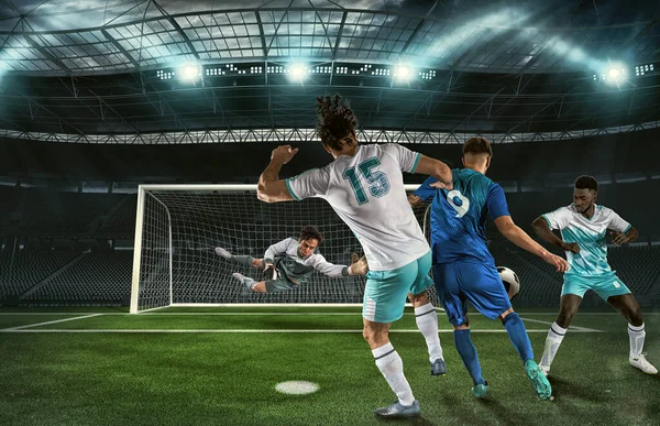 サッカー選手3人とゴアリーがスタジアムでボールを追いかける — ストック写真
