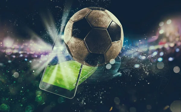 Futbol sahasında cep telefonu ve top.