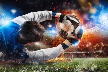 Stadyumdaki kaleci hızlı bir futbol topu yakalıyor.