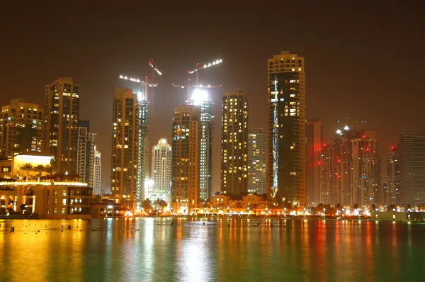 Neue Wolkenkratzer in Dubais Innenstadt und künstlich angelegter See in der Nacht — Stockfoto