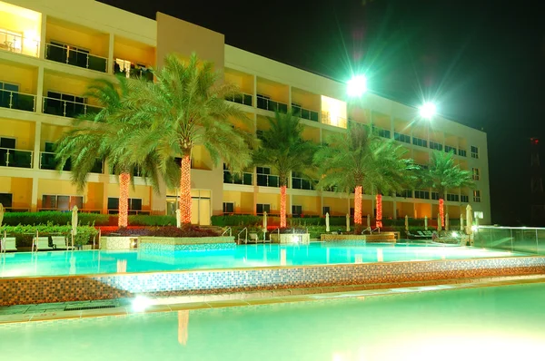 Πισίνα και το κτίριο του ξενοδοχείου πολυτελείας σε illumina νύχτα — Φωτογραφία Αρχείου