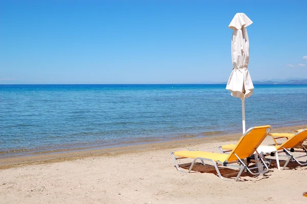 Lettini su una spiaggia e acqua turchese al moderno hote di lusso — Foto Stock