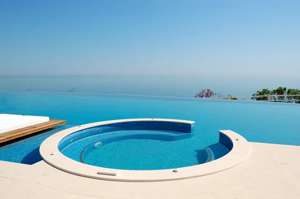 Infinity swimming pool with jacuzzi by beach at the modern luxur — Stock Photo, Image