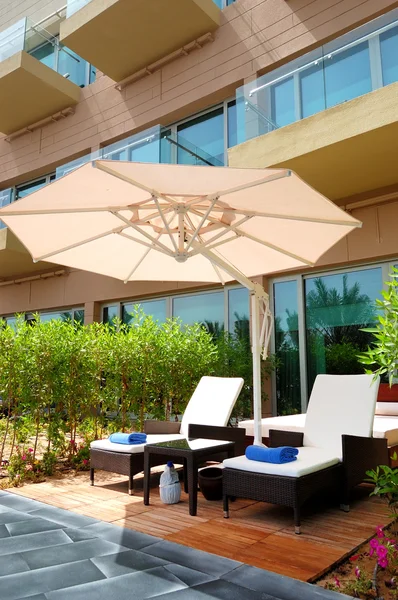 Sunbeds and umbrella near building of luxury hotel, Dubai, UAE — Stock Photo, Image