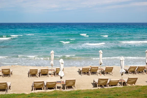 Lettini su una spiaggia e acqua turchese al moderno hote di lusso — Foto Stock