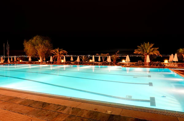 Éjszakai megvilágítás mellett a luxus forró strand közelében uszoda — Stock Fotó
