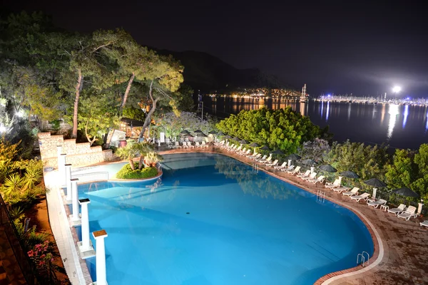 La piscina y la vista sobre el puerto de yates en la iluminación nocturna — Foto de Stock