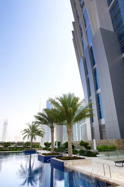 La piscina cerca de rascacielos, Dubai, Emiratos Árabes Unidos — Foto de Stock