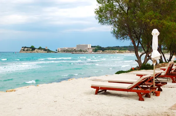 Solstolar på en strand och turkos vatten på modern lyx hote — Stockfoto