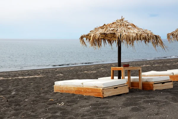 La playa con piedras volcánicas negras en la isla de Santorini, Grecia —  Fotos de Stock