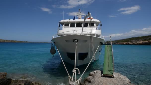 Традиционная греческая моторная яхта для перевозки туристов находится недалеко от пляжа, Крит, Греция — стоковое видео
