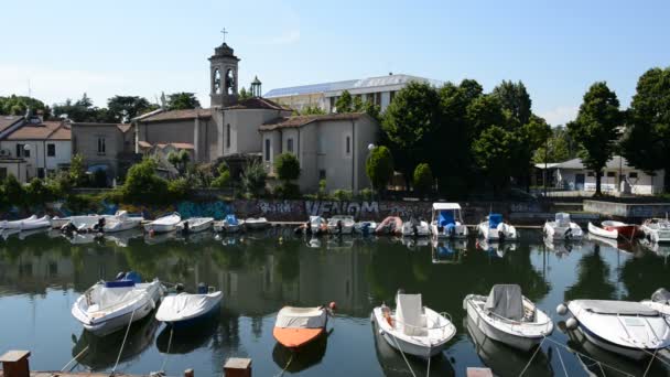 El canal de agua con lanchas a motor estacionadas y la iglesia católica, Rímini, Italia — Vídeos de Stock