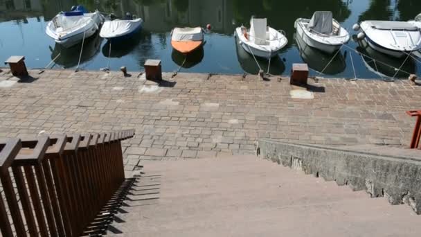 La panorámica del canal de agua con lanchas motoras estacionadas y la iglesia católica, Rímini, Italia — Vídeos de Stock