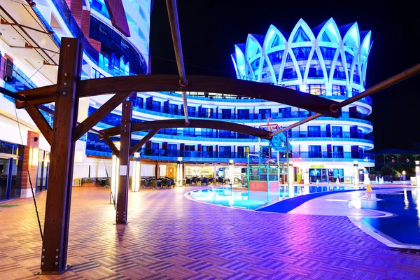 Plavecký bazén a budova luxusního hotelu v noci illumina — Stock fotografie