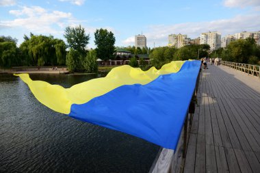 BILA TSERKVA, UKRAINE - 22 AĞUSTOS Ukrayna Ulusal Bayrağının Ukrayna Bağımsızlık Günü 'ne adanmış görüntüsü, 22 Ağustos 2020 tarihinde Ukrayna' nın Bila Tserkva kentinde Ros Nehri üzerindeki ahşap köprüde yatmaktadır.. 