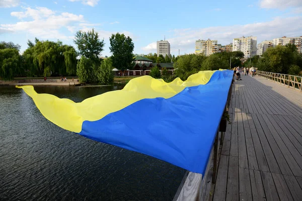 BILA TSERKVA, UKRAINE - 22 AĞUSTOS Ukrayna Ulusal Bayrağının Ukrayna Bağımsızlık Günü 'ne adanmış görüntüsü, 22 Ağustos 2020 tarihinde Ukrayna' nın Bila Tserkva kentinde Ros Nehri üzerindeki ahşap köprüde yatmaktadır.. 