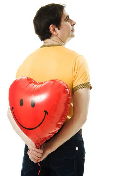 Joven sosteniendo un globo rojo en forma de corazón — Foto de Stock