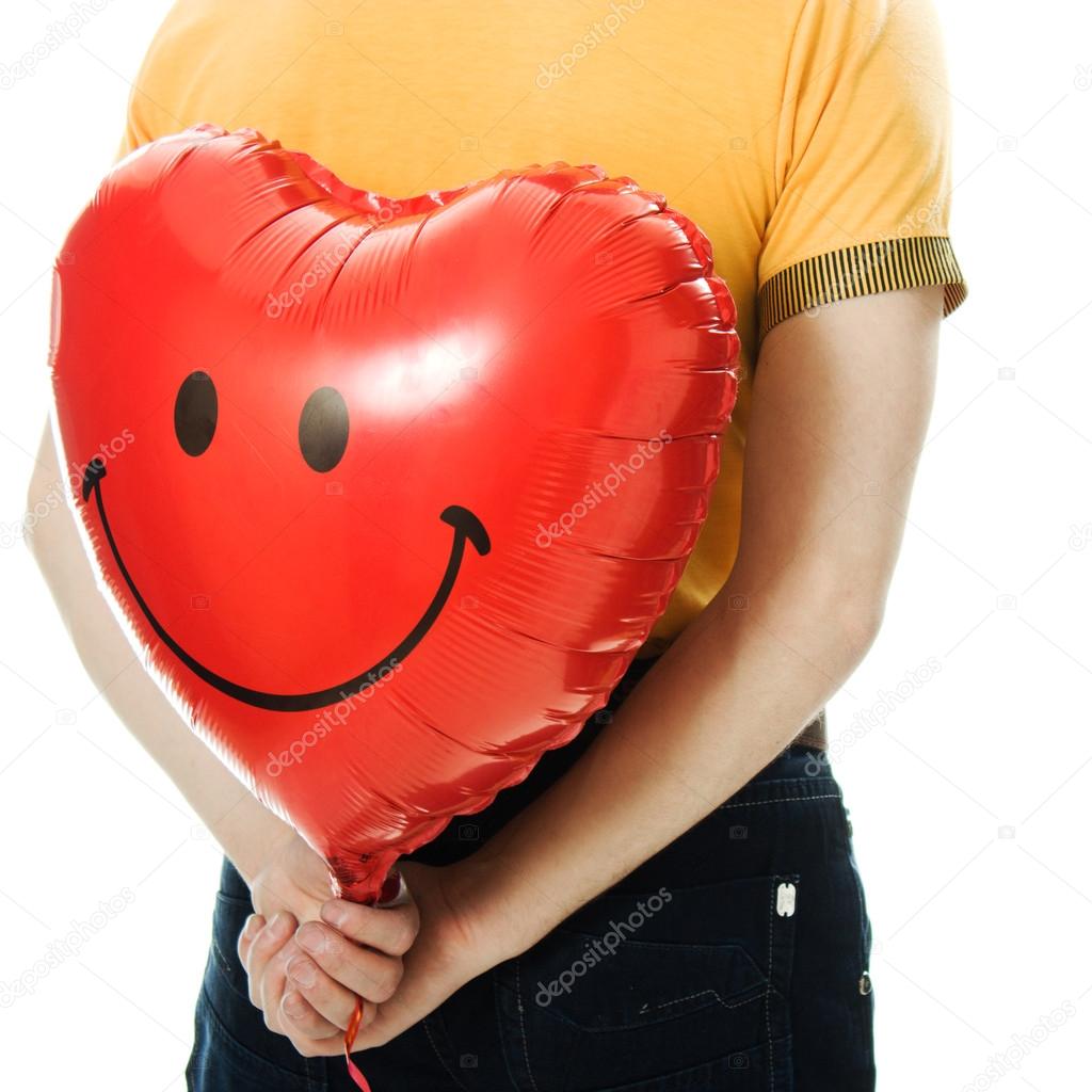 young man holding a red heart shaped balloon