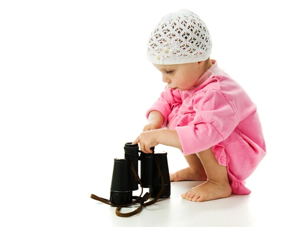 Girl in pink dress with a pair of binoculars — Stock Photo, Image