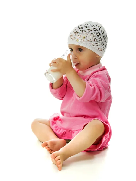 A pretty little girl is holding a glass of milk isolated on the white background — Stock Photo, Image