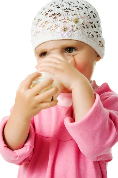 Całkiem mała dziewczynka trzyma kieliszek z mleko na białym tle na białym tle — Zdjęcie stockowe
