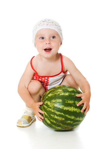 Очаровательный ребенок счастливо играет на арбузе.
