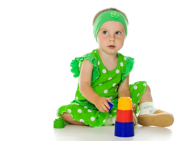 Little girl is playing with toy pyramid — Stockfoto