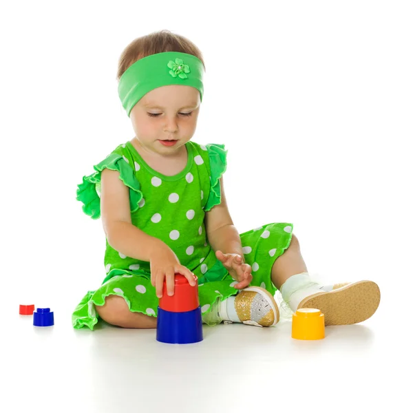 Little girl is playing with toy pyramid — Stock Photo, Image