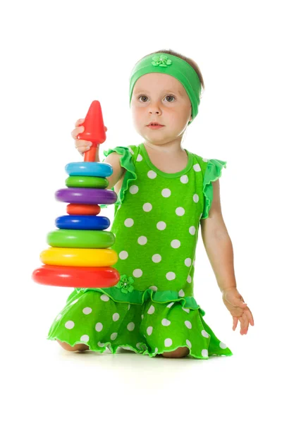 Klein meisje is spelen met speelgoed piramide — Stockfoto