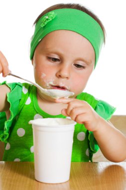 Kız bir kaşık süt ürünleri ile eats.